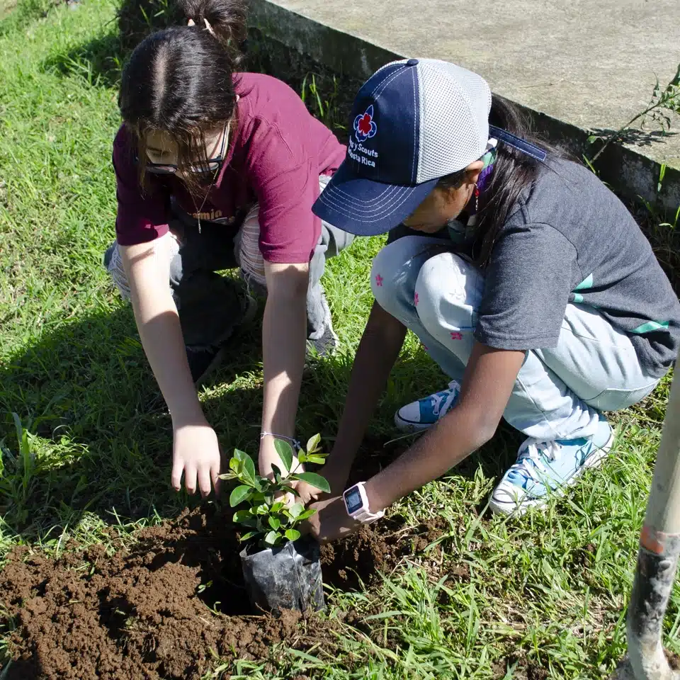 Dos niños sembrando una planta